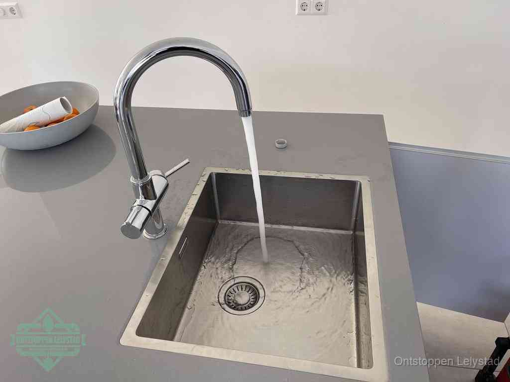 Een vrij doorstromende rvs spoelbak waar het water moeiteloos wegloopt, het resultaat van slim onderhoud dat geld bespaart in Lelystad