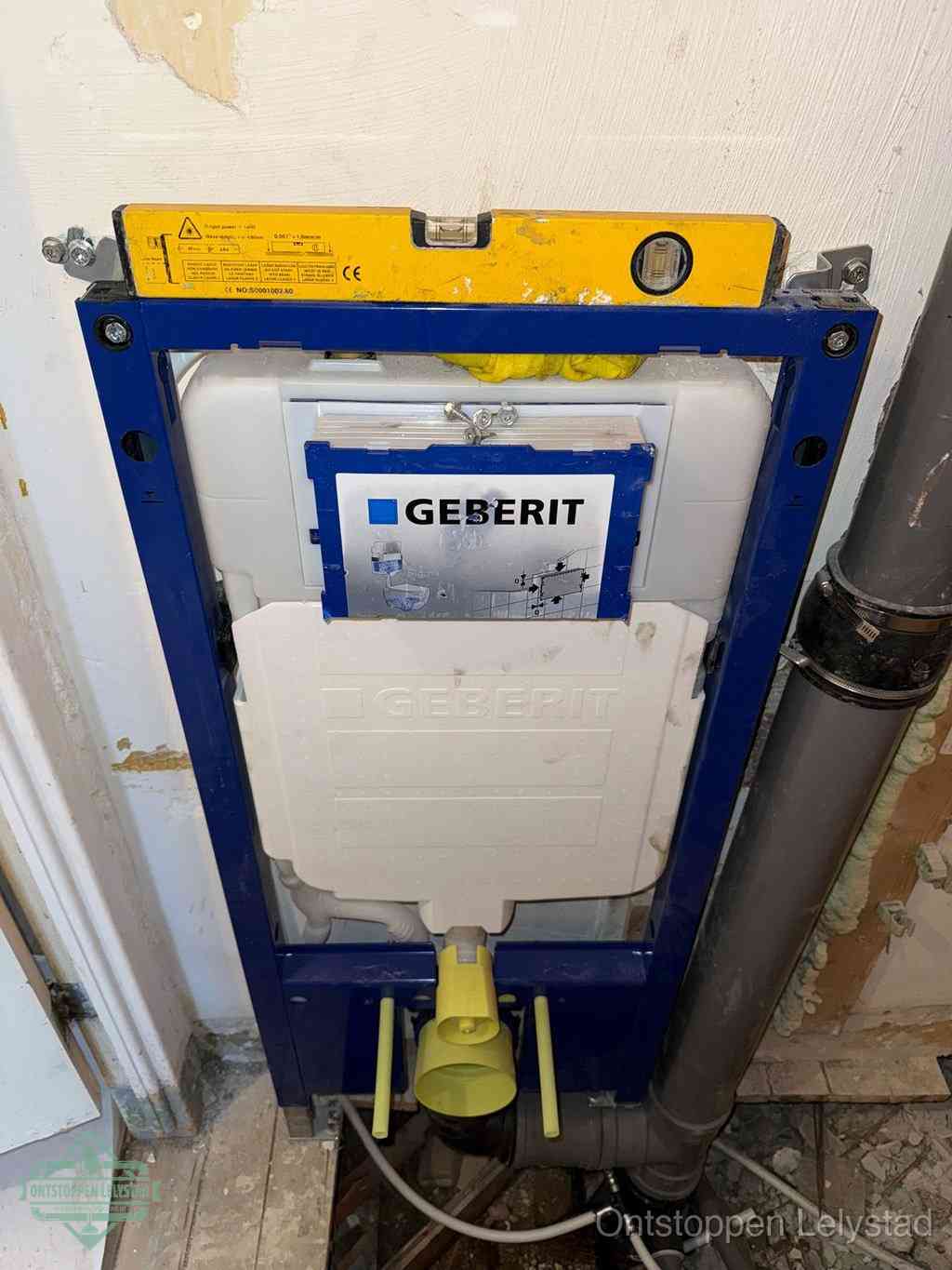 Een Geberit inbouwreservoir met frame voor een hangtoilet tegen de wand, met de afvoerbocht naar de vloer, kenmerkend voor een verstopt hangtoilet in Lelystad