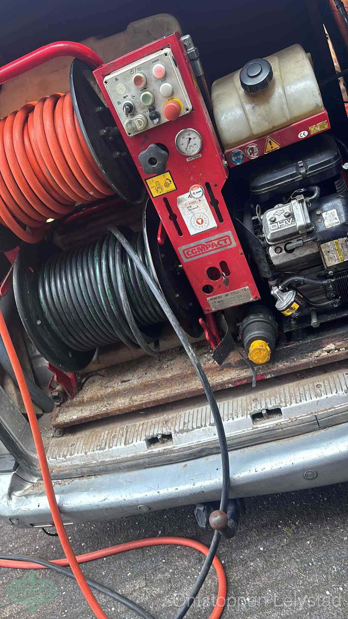 Een rood hogedruk-rioolreinigingstoestel in de laadbak van de bedrijfsbus, apparatuur voor een hardnekkige afvoerverstopping in Lelystad