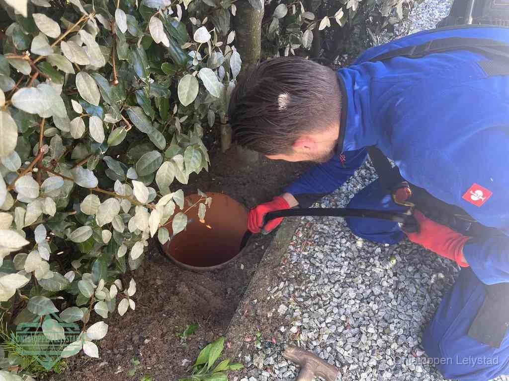 Monteur reinigt een rioolput met een slang, periodieke rioolreiniging in Lelystad