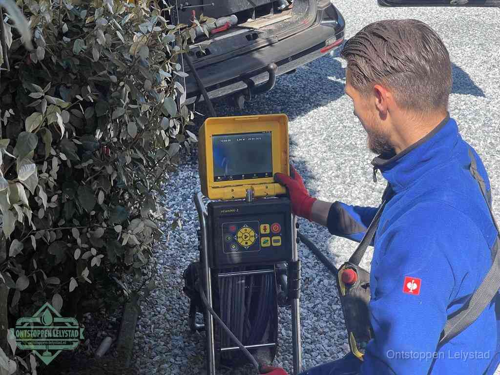 Monteur bedient een rioolinspectiecamera met monitor voor rioolinspectie in Lelystad