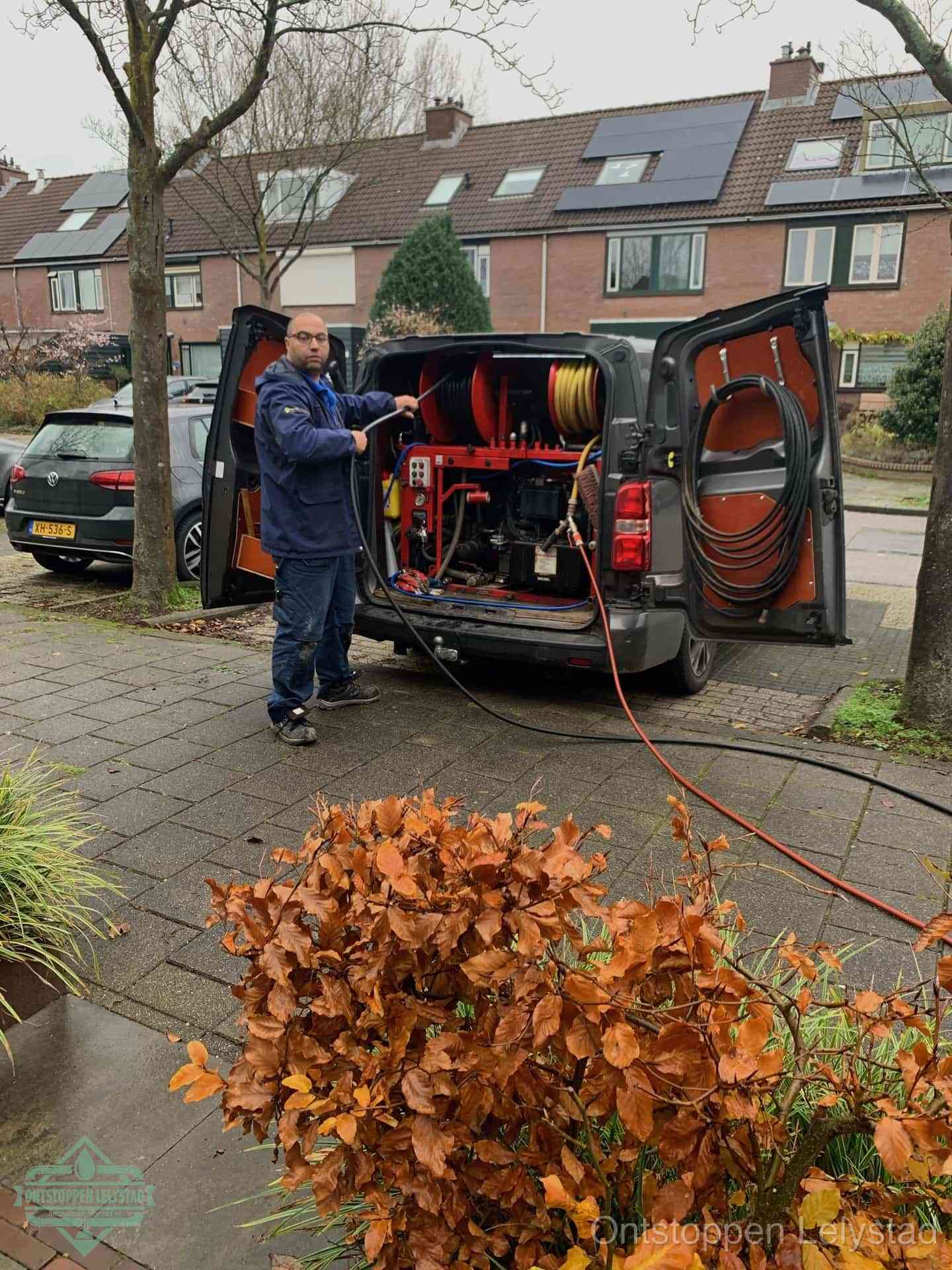 Monteur met rioolreinigingsbus levert rioolservice in de wijk in Lelystad